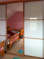 High gloss black sliding children's wardrobe with mirror - fitted by Barrett Kitchens, Letterkenny, Co. Donegal, Ireland